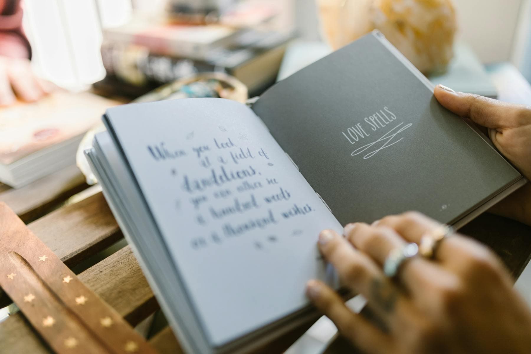Hands flipping pages of an open printed booklet in natural light