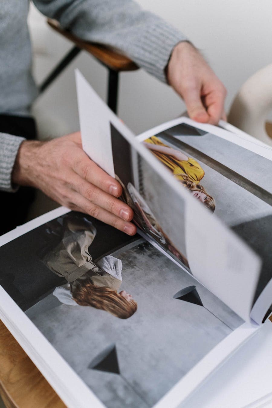Open printed booklet pages being turned by hand
